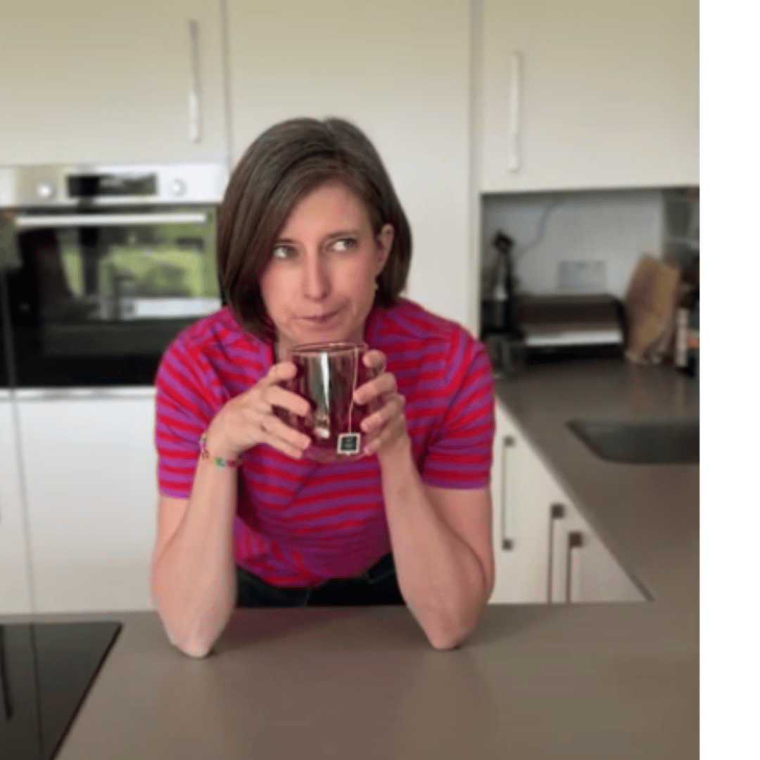 Image of a woman in a stripy purple and red t-shirt drinking a cup of HotTea Mama tea