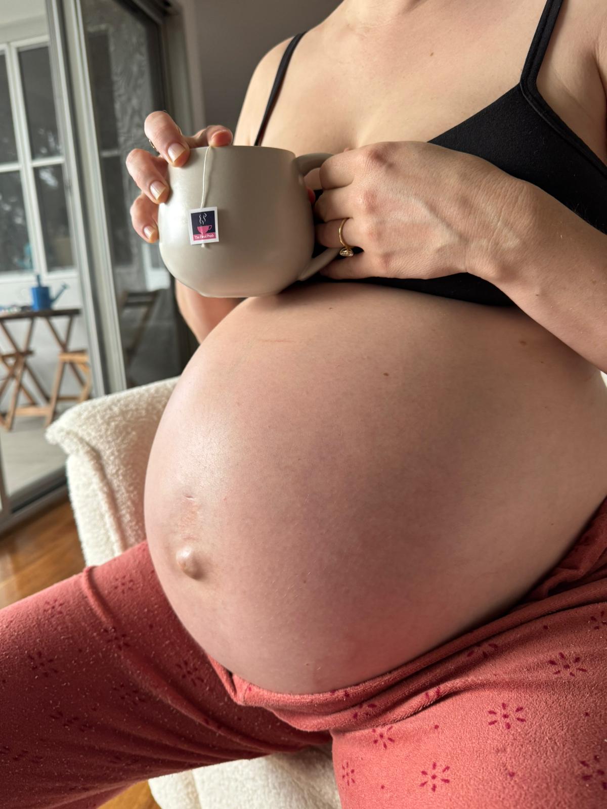 Woman with a cup of The Final Push resting on her pregnancy bump