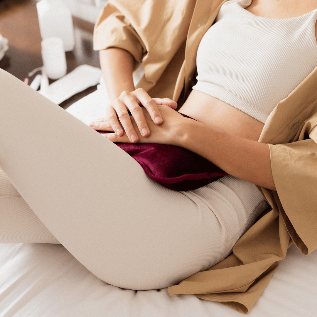 Image of a woman with hot water bottle to alleviate menstrual pain